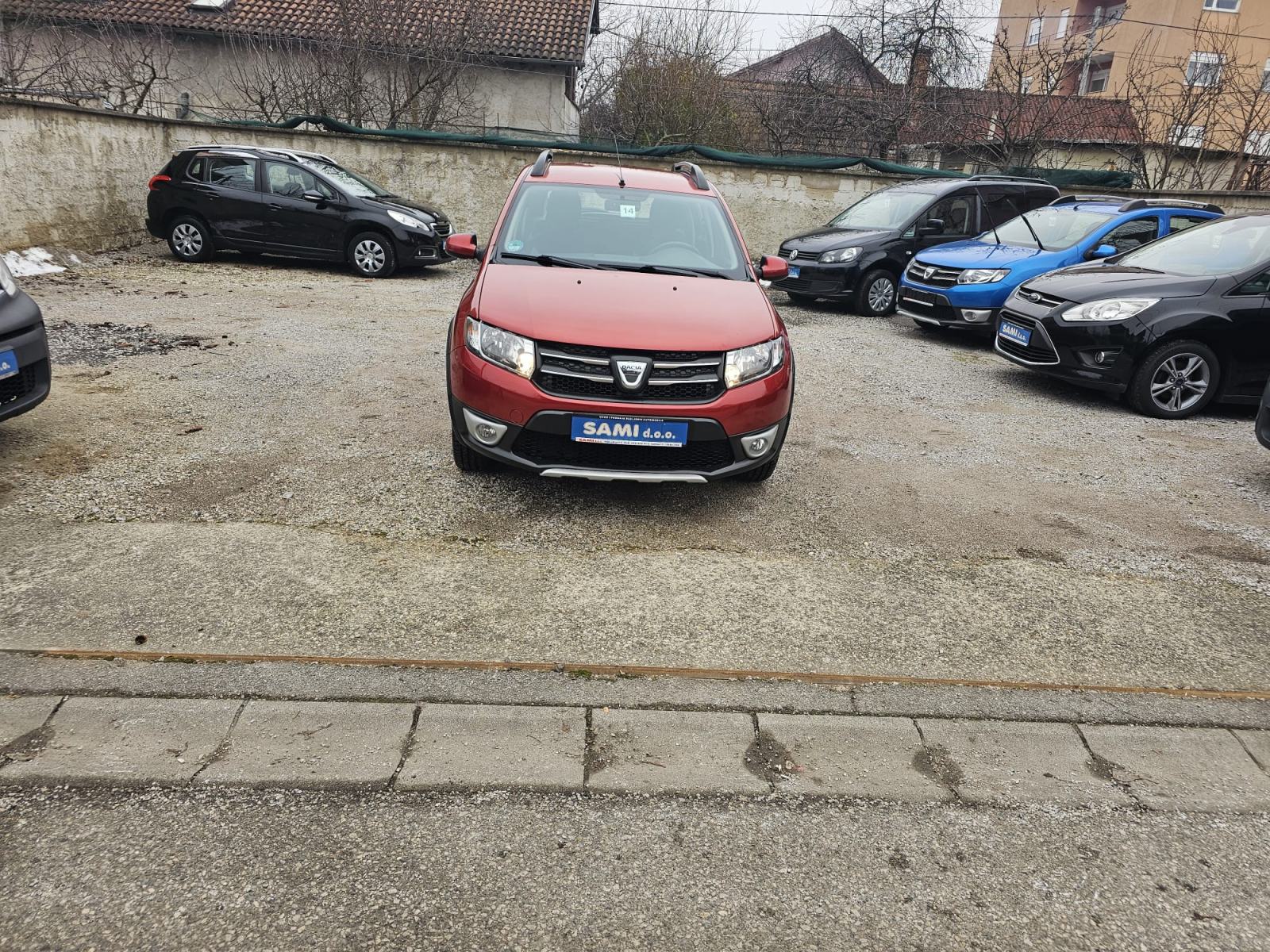 Slika prikazuje vanjsku stranu vozila na parkingu.