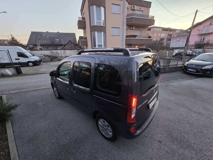 Slika prikazuje vanjsku stranu vozila u parkiralištu.