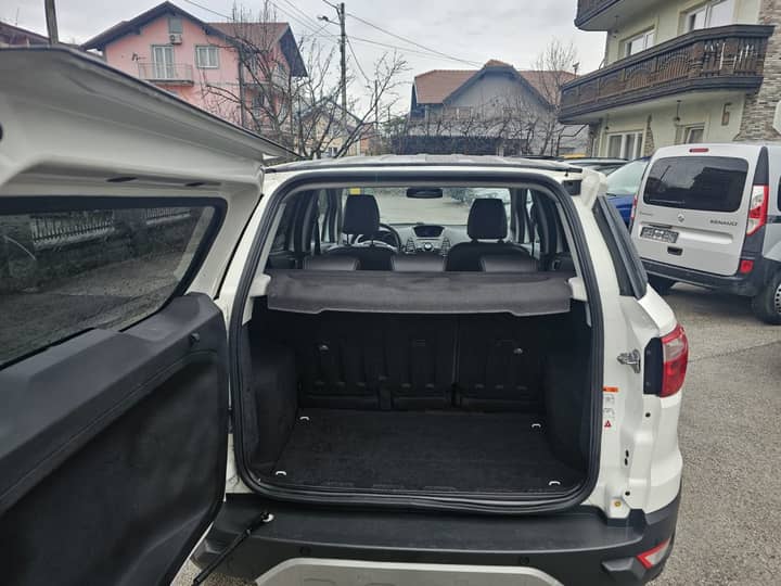 Slika prikazuje vanjski dio vozila s otvorenim poklopcem prtljažnika.