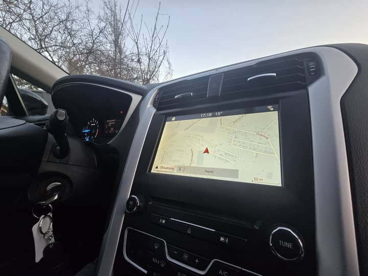 Slika prikazuje unutrašnjost vozila, kokpit i infotainment.