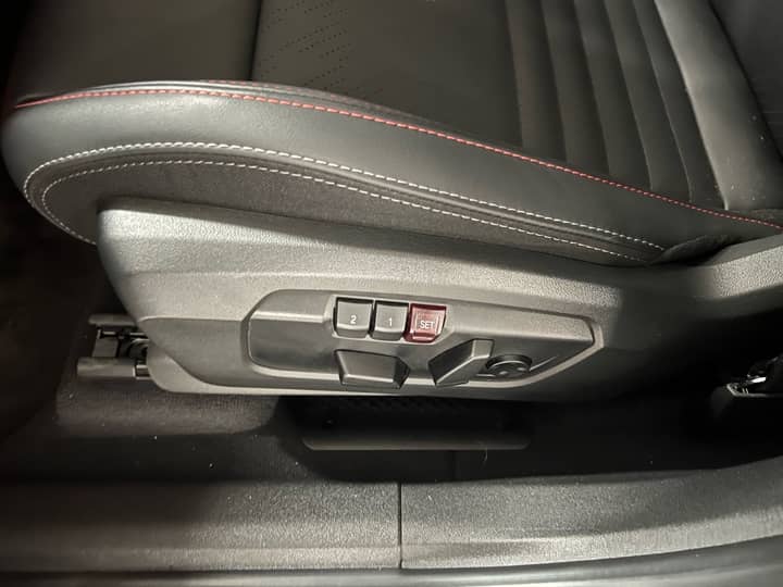 Slika prikazuje unutrašnjost vozila, fokus na kontrolama sjedala.