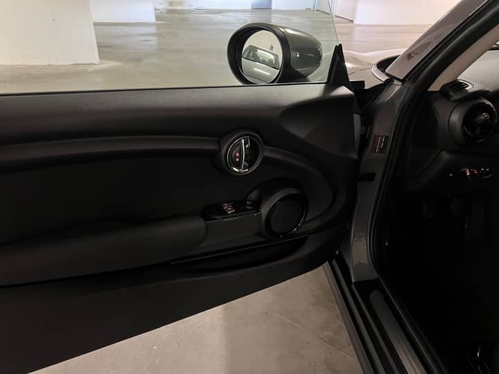 Slika prikazuje unutrašnjost vozila – prednja vrata i kontrolni panel.