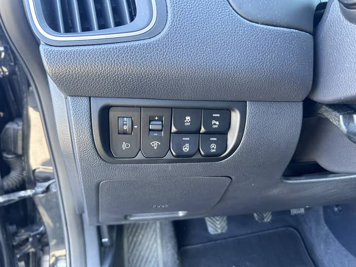 Slika prikazuje unutrašnjost vozila – panel s kontrolnim gumbima.