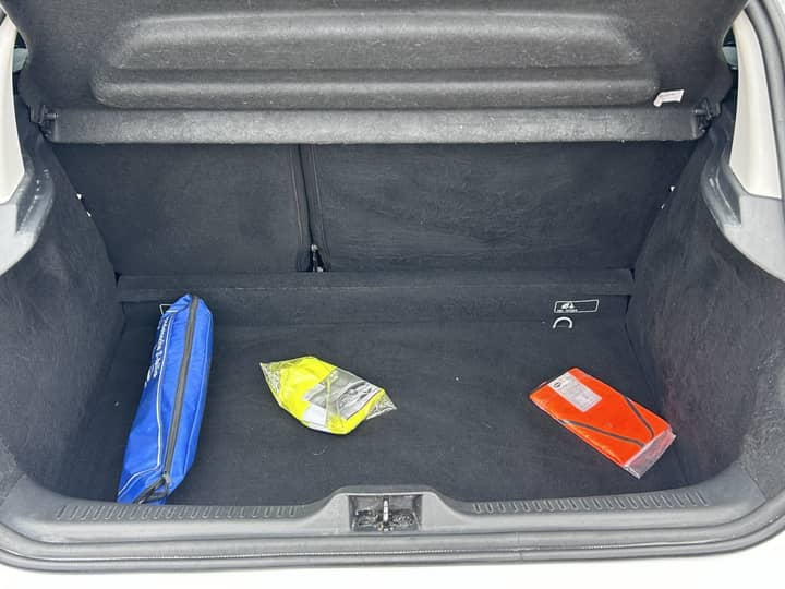 Slika prikazuje unutrašnjost prtljažnika automobila s predmetima.