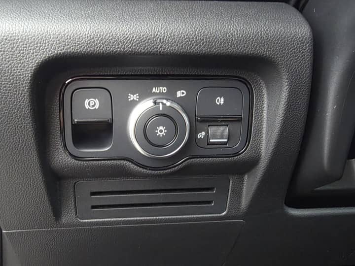 Slika prikazuje unutrašnjost vozila — kontrolni panel i prekidače.