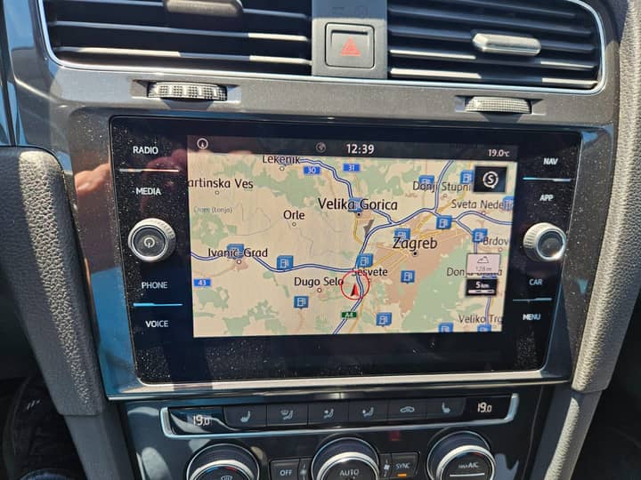 Slika prikazuje unutrašnjost vozila (dashboard i navigacijski ekran).