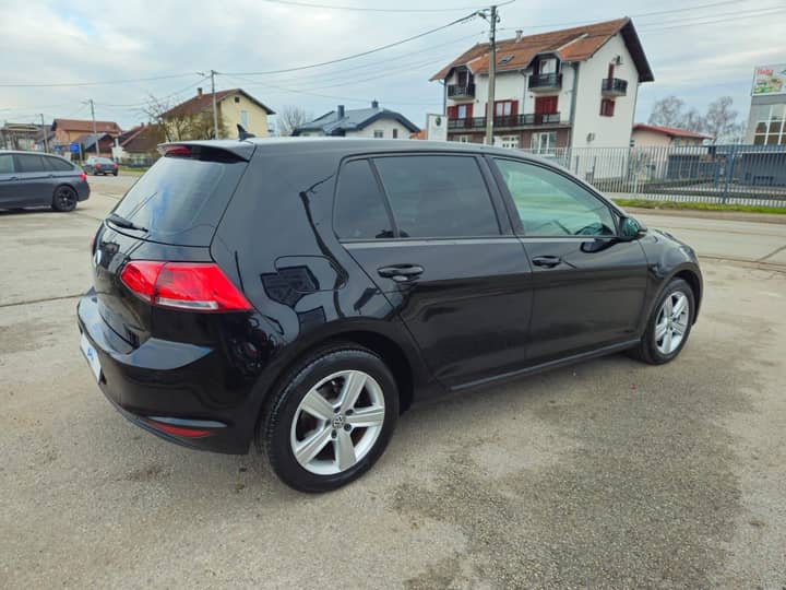 Slika prikazuje vanjsku karoseriju vozila i djelomično okruženje.