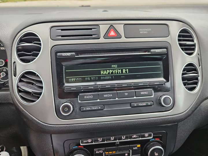 Slika prikazuje unutrašnjost vozila (dashboard, radio).