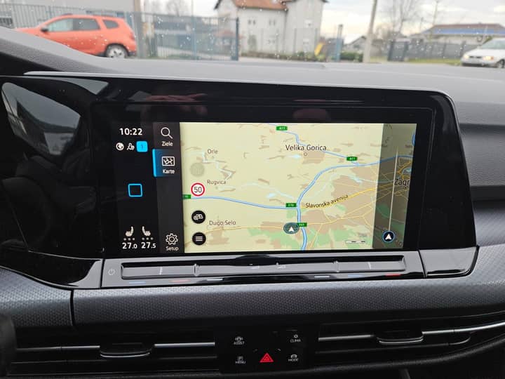 Slika prikazuje unutrašnjost vozila; zaslon navigacije i instrumentna ploča.
