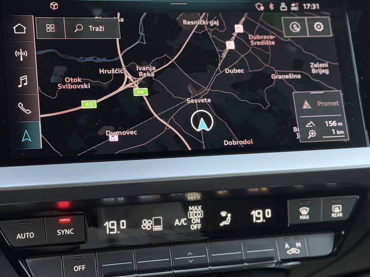 Slika prikazuje interijer vozila s navigacijskim zaslonom.