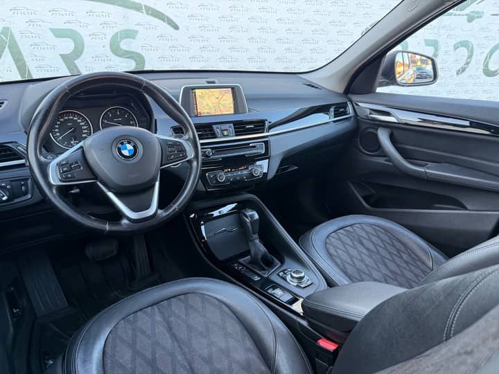 Slika prikazuje unutrašnjost vozila (volan i sjedala).
