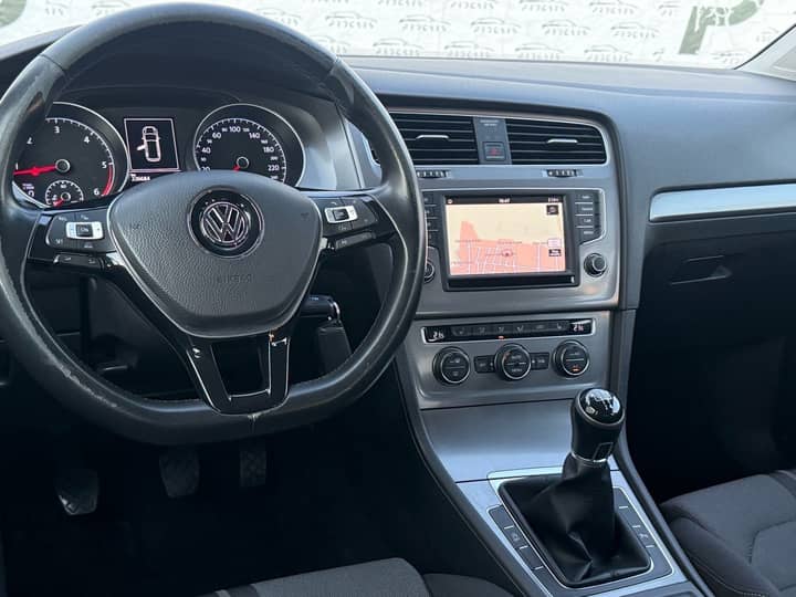 Slika prikazuje unutrašnjost vozila: volan i središnji dio.