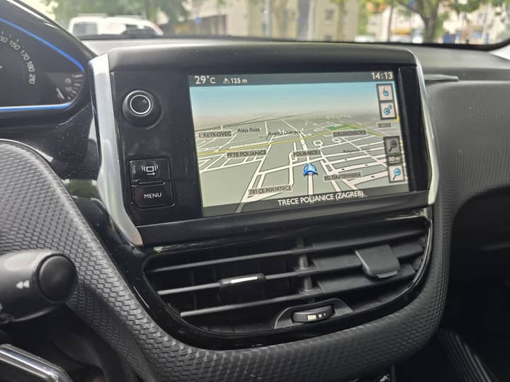 Slika prikazuje interijer vozila s navigacijskim zaslonom.
