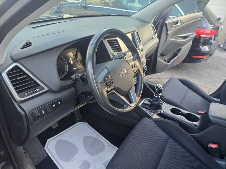 Slika prikazuje unutrašnjost vozila – volan, instrument ploča i sjedala.