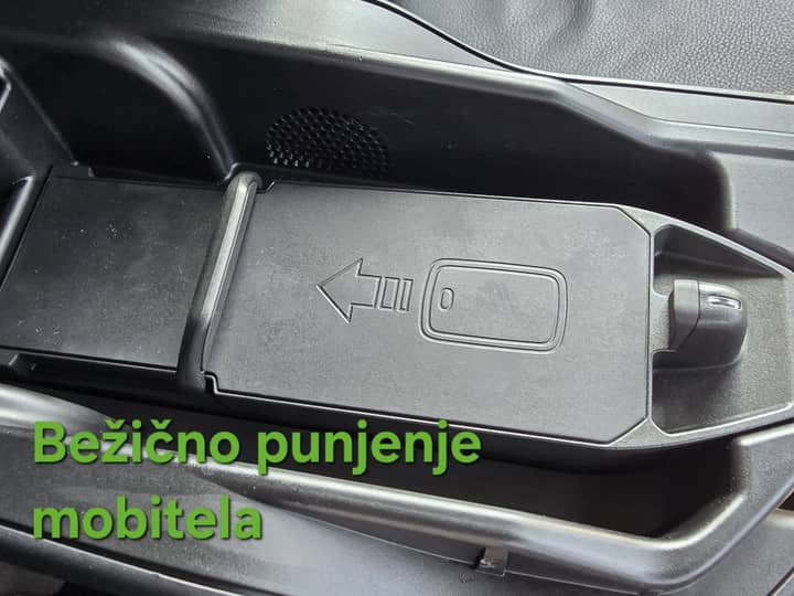Slika prikazuje unutrašnjost vozila, fokus na bežično punjenje.
