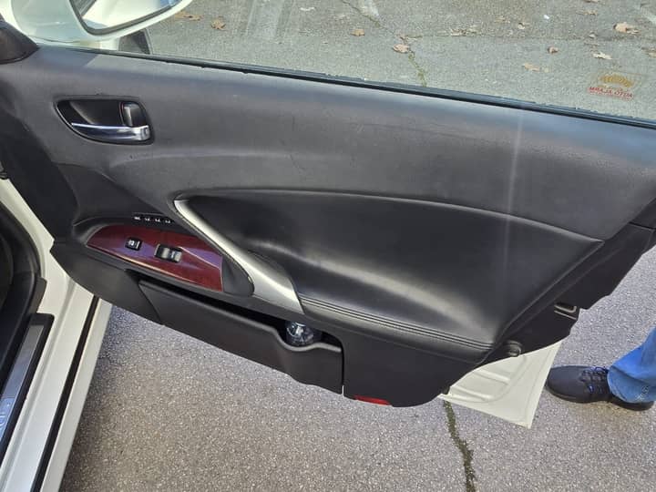 Slika prikazuje unutrašnjost vozila, vrata i panel.