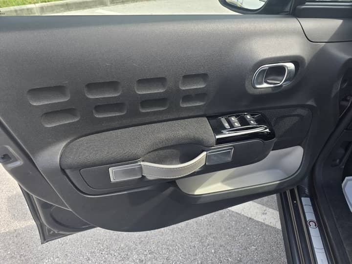 Slika prikazuje unutrašnjost vozila (panel vrata i kontrole).