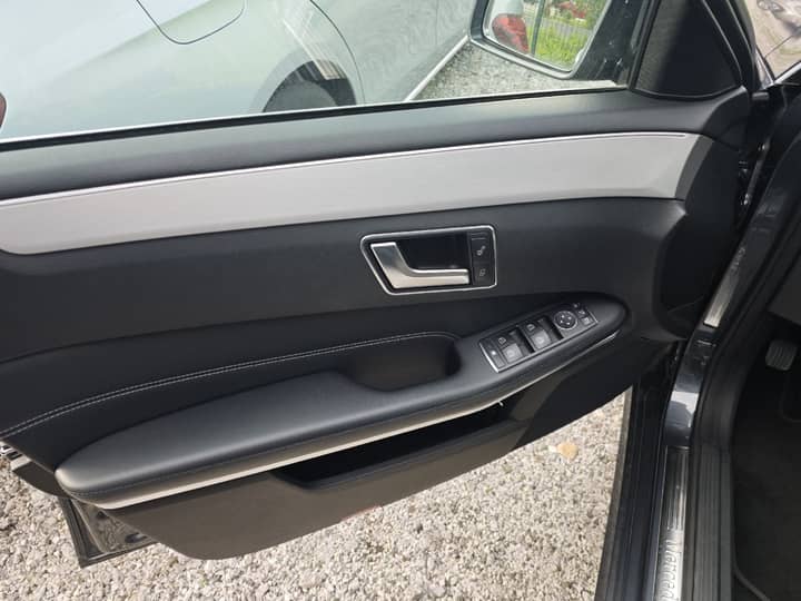 Slika prikazuje unutrašnjost vozila - vrata i panel kontrole.