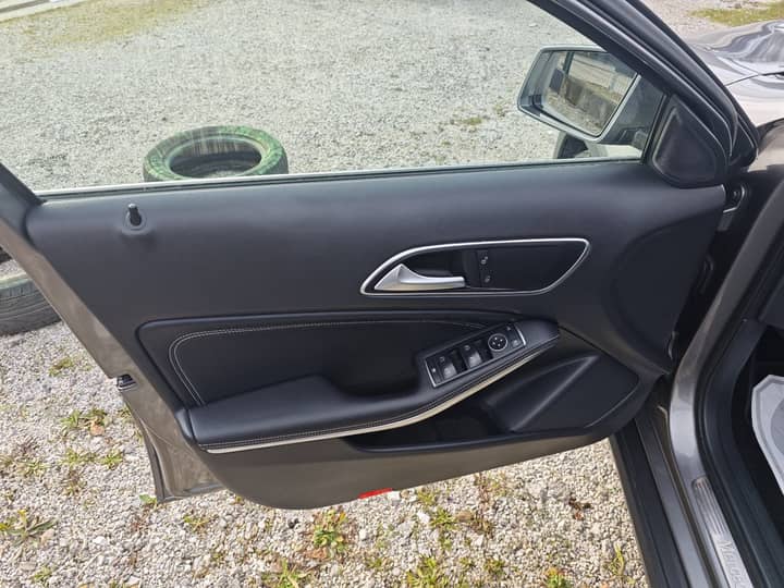 Slika prikazuje unutrašnjost vozila – panel vrata i kontrole prozora.