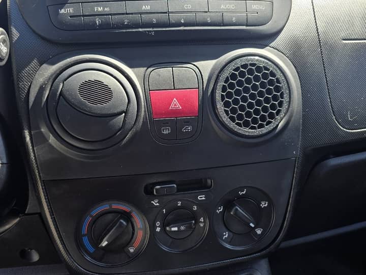 Slika prikazuje unutrašnjost vozila, upravljački panel i kontrole.
