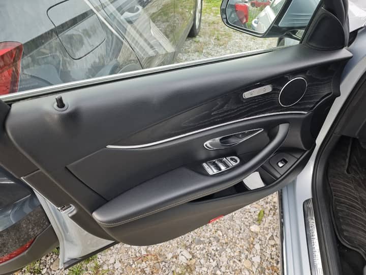 Slika prikazuje unutrašnjost vozila (vrata i panel kontrole).