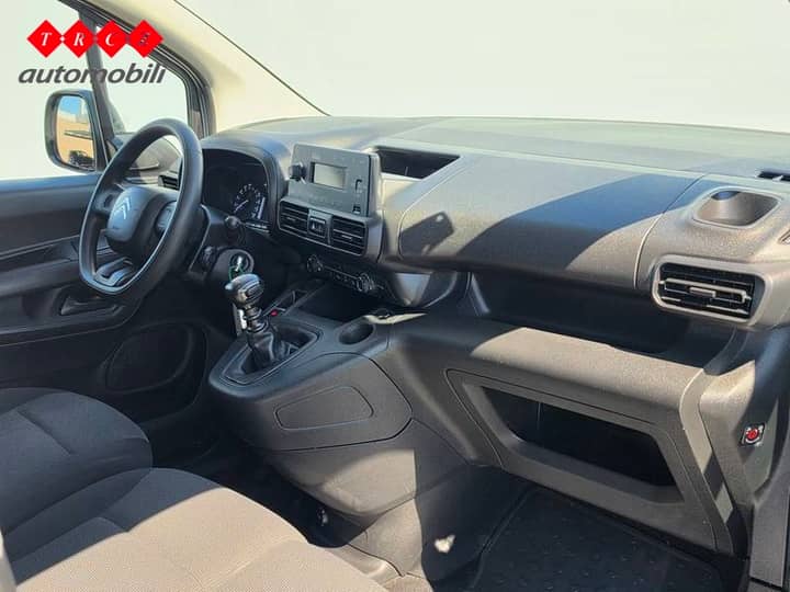 Slika prikazuje unutrašnjost vozila – kokpit i sjedala.