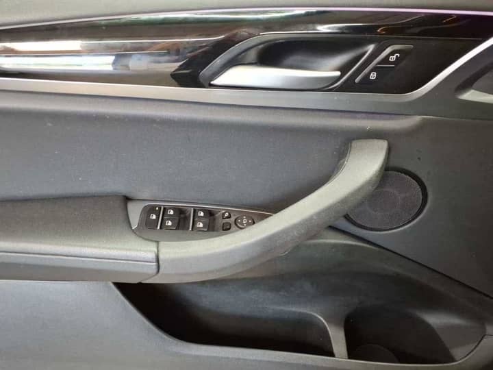 Slika prikazuje unutrašnjost vozila, panel vrata i kontrole.
