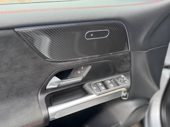 Slika prikazuje unutrašnjost vozila – panel vrata i kontrole.
