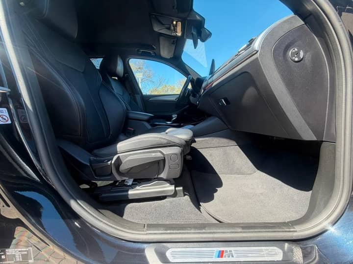 Slika prikazuje unutrašnjost vozila, fokus na sjedala i upravljač.