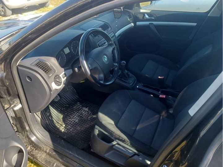 Slika prikazuje unutrašnjost vozila (volan i sjedala).
