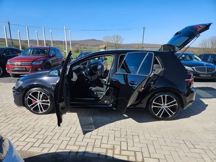 Slika prikazuje vanjski dio vozila; auto s otvorenim vratima.