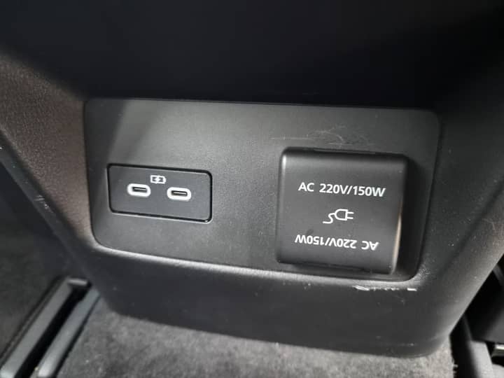 Slika prikazuje unutrašnjost vozila s utičnicom za napajanje.