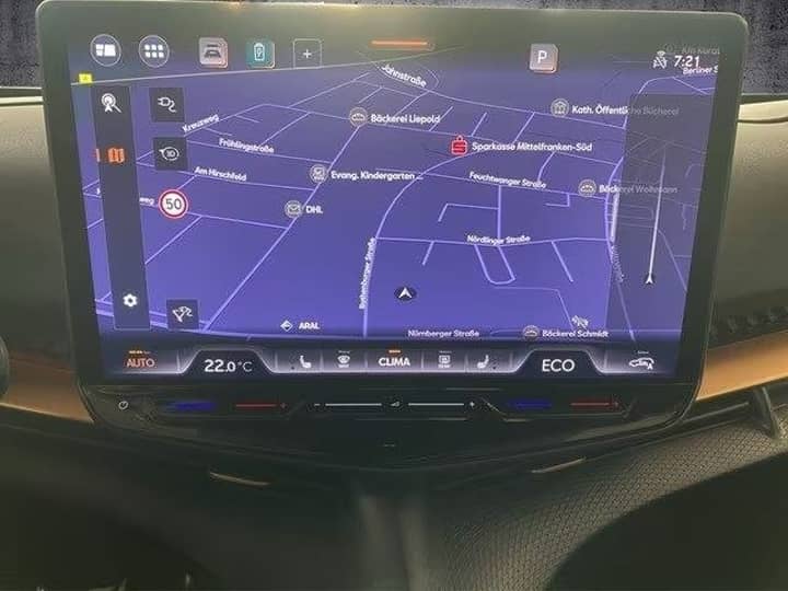 Slika prikazuje unutrašnjost vozila s navigacijskim zaslonom.