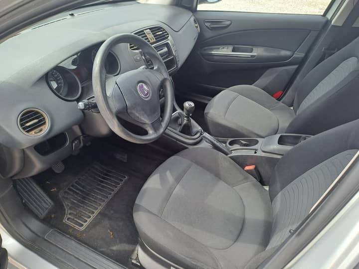 Slika prikazuje unutrašnjost vozila (volan i sjedala).