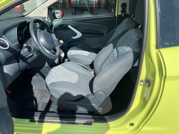 Slika prikazuje unutrašnjost vozila (sjedala i volan).