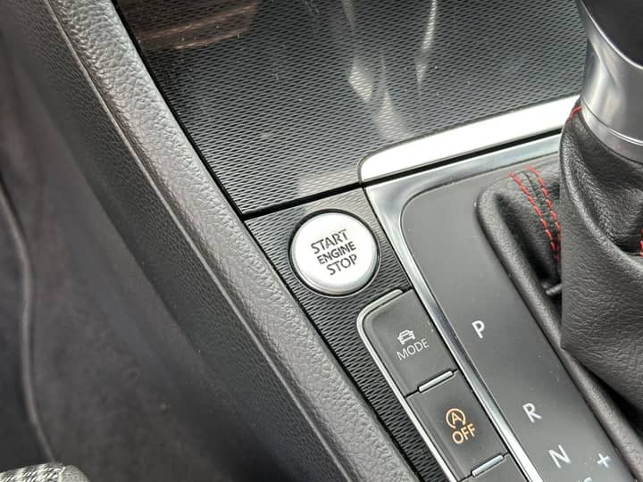 Slika prikazuje unutrašnjost vozila s gumbom Start/Stop i mjenjačem.