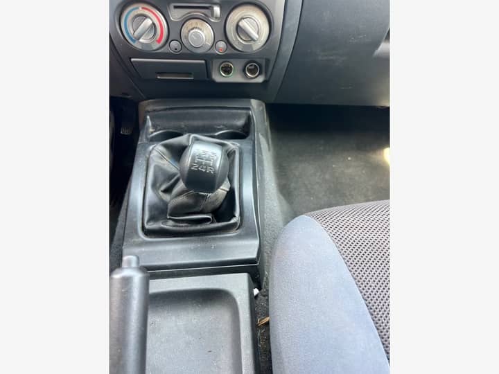 Slika prikazuje unutrašnjost vozila – mjenjač i srednja konzola.