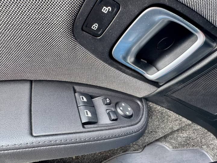 Slika prikazuje unutrašnjost vozila – panel kontrole prozora.