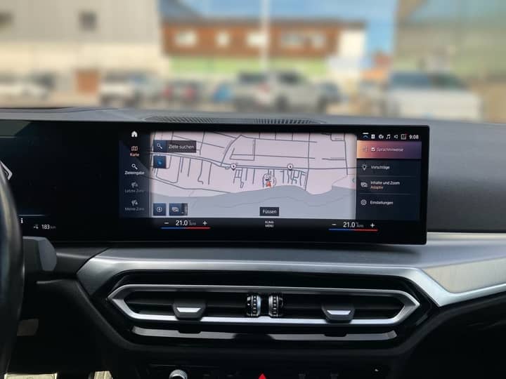 Slika prikazuje unutrašnjost vozila s središnjim zaslonom navigacije.