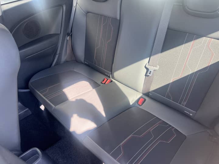Slika prikazuje unutrašnjost stražnjih sjedala automobila.