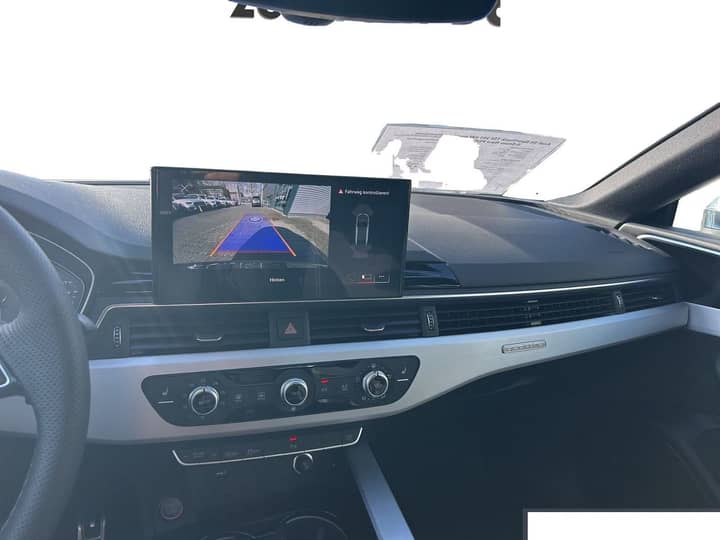 Slika prikazuje unutrašnjost vozila (dashboard i zaslon).
