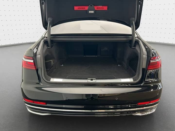 Slika prikazuje vanjski stražnji dio automobila s otvorenim prtljažnikom.