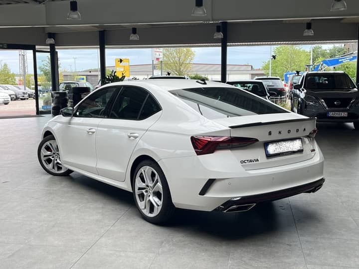 Slika prikazuje vanjštinu automobila na parkiralištu.