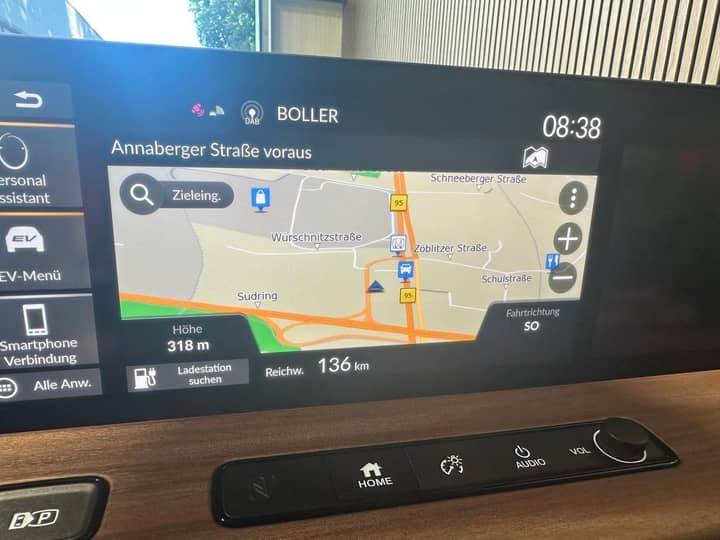 Slika prikazuje unutrašnjost vozila s navigacijskim zaslonom.