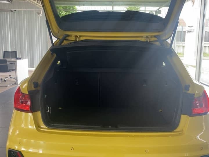 Slika prikazuje vanjski stražnji dio automobila s otvorenim prtljažnikom.