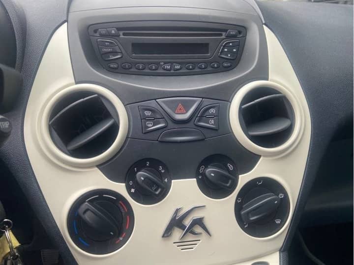 Slika prikazuje unutrašnjost vozila, središnji panel i kontrole.