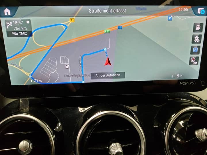 Slika prikazuje unutrašnjost vozila sa zaslonom navigacije.