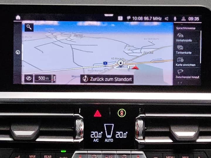 Slika prikazuje unutrašnjost vozila s navigacijskim zaslonom.