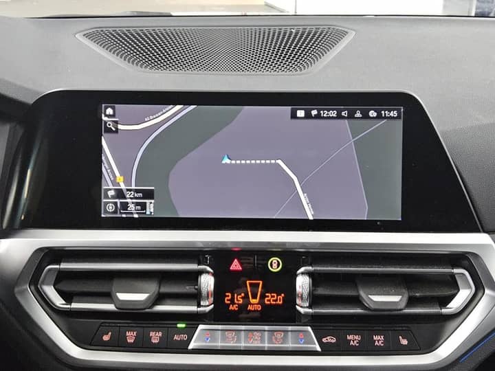 Slika prikazuje unutrašnjost vozila (navigacijski zaslon i klima).