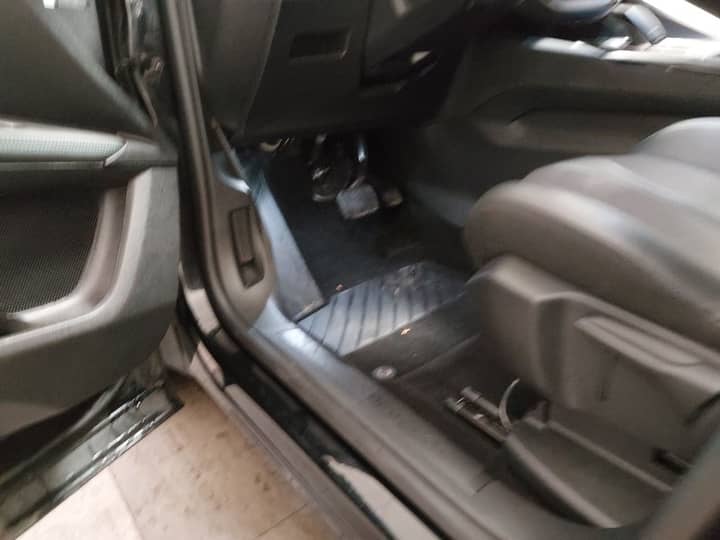 Slika prikazuje unutrašnjost vozila (volan i sjedala).